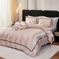 a bed with pink sheets and pillows in a room