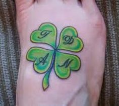 a foot with a four leaf clover tattoo on it