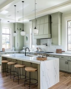 a large kitchen with marble counter tops and stools in front of an island that has four bar stools on it