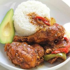 a white plate topped with rice and meat next to an avocado slice on top of it