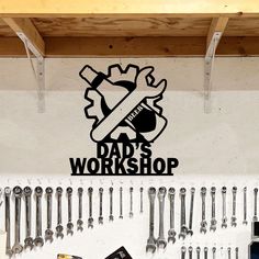 there is a sign that says dad's workshop with tools hanging on the wall