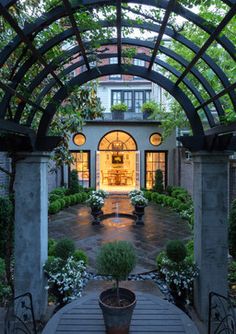 an outdoor patio with potted plants and lights on the door way to a house