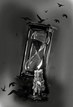 black and white photograph of an hourglass with birds flying around