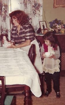 an old photo of a woman and two children sitting at a table with dolls in front of them