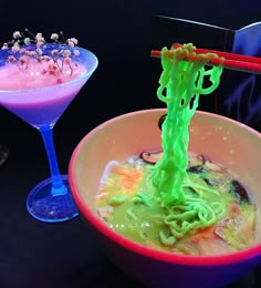 there are two bowls with food in them and one has green noodles on the side