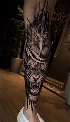 a man's leg with an owl and wolf tattoo on it