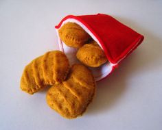 three pieces of bread sitting in a small red bag on a white table top next to each other