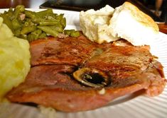 a white plate topped with meat, potatoes and green beans