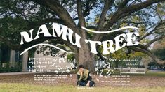 a man kneeling under a tree in front of a sign that says namu tree