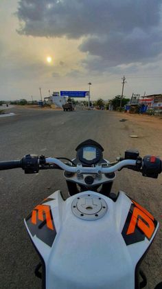 a motorcycle parked on the side of a road under a cloudy sky