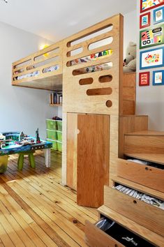 there is a loft bed in the middle of this room with wooden floors and stairs