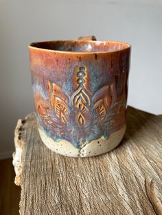 a brown and blue cup sitting on top of a wooden table