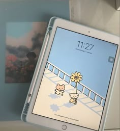 an ipad sitting on top of a table next to a photo and a flower in front of it