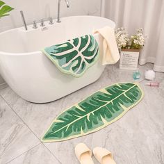 a bathroom with a bathtub, rug and slippers on the floor next to it