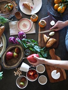 people sitting at a table with plates and bowls of food on it, including bread