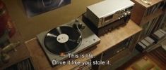 a record player sitting on top of a wooden shelf