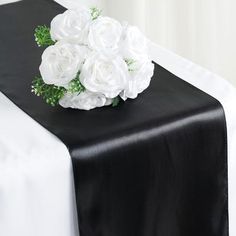 a black table runner with white flowers on it