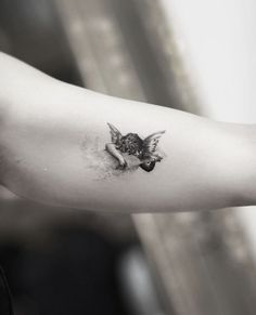 a black and white photo of a person's arm with a bird on it