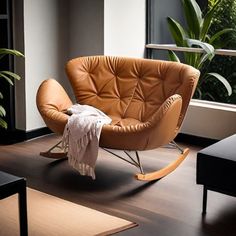 a brown leather rocking chair sitting on top of a wooden floor next to a window