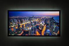 an aerial view of a city at night from the top of a tall building with lights on