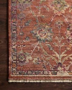 an orange rug on a wooden floor with a brown and blue floral design in the middle