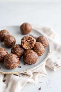 several chocolate balls on a plate with one cut in half to show the fillings