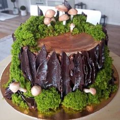 a cake decorated with moss and mushrooms on a table