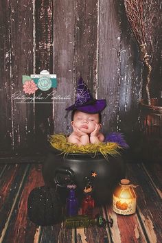 a baby wearing a witches hat and sitting in a witch's caulder