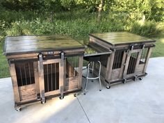 two wooden crates sitting next to each other on top of a cement floor in front of trees