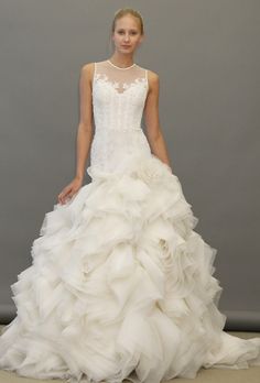 a woman in a white wedding dress on the runway