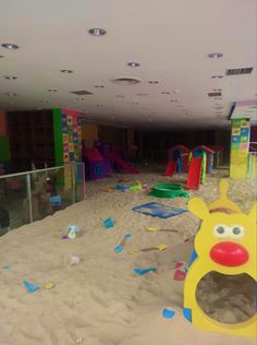 children's play area with slides and toys in the sand at an indoor playground