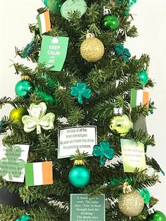 a small christmas tree with green and gold ornaments on it's branches, which are decorated with irish flags