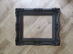 a black frame sitting on top of a wooden floor