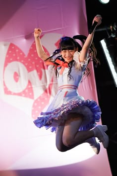 a girl is jumping in the air on stage