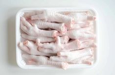 raw chicken pieces in a container on a white surface