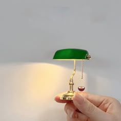 a person holding a green lamp in their hand with the light turned on and off