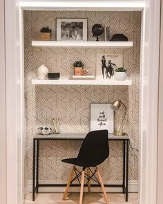 a black chair sitting in front of a white shelf filled with pictures and other items