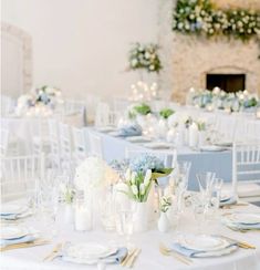 the tables are set up with white and blue linens for an elegant wedding reception