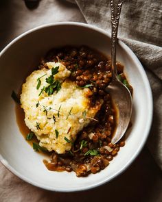 a white bowl filled with mashed potatoes and lentils