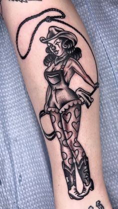 a woman with a cowboy hat and boots on her leg is holding a lasso