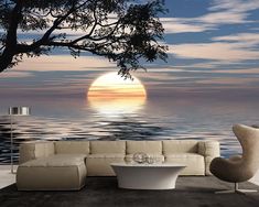 a living room scene with the sun setting over the ocean and tree in the foreground