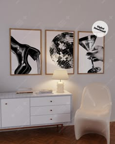 a white chair sitting in front of two pictures on the wall