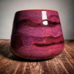 a purple vase sitting on top of a wooden table