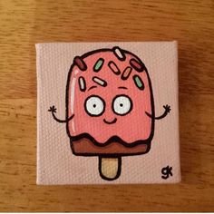 a pink ice cream covered in sprinkles on top of a wooden table