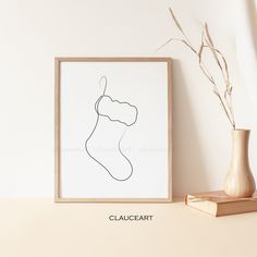 a drawing of a christmas stocking on a shelf next to a vase with a plant in it