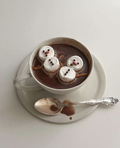 hot chocolate with marshmallows and snowmen in it on a white plate