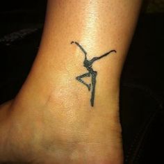 a small tattoo on the ankle of a woman's foot with a black and white image of a dancer