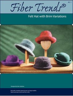 the cover of fibertrends magazine featuring different hats on wooden sticks and a green background