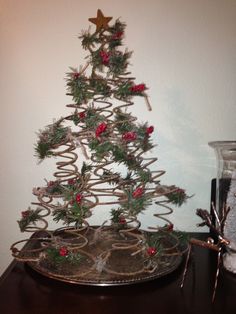 a small christmas tree sitting on top of a wooden table next to a glass jar