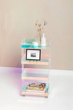 a stack of books sitting on top of a table next to a vase filled with flowers